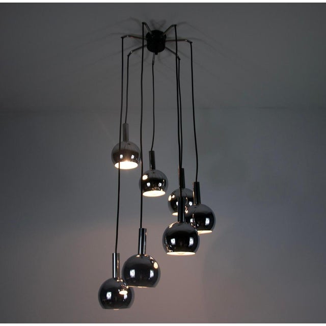 Stunning space age cascading ceiling lamp from the 1970s, featuring seven metal shades in a sleek, futuristic design. This...