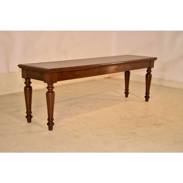 19th century oak bench from England with lovely hand turned legs. The top has lovely graining and is banded , surrounding...