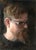 This oil painting presents a close-up portrayal of a man with striking facial features and a thoughtful expression, set...