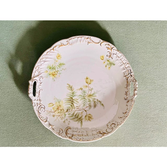 A beautiful wildflower and fern pattern handled serving plate with gold scrollwork trimmings.