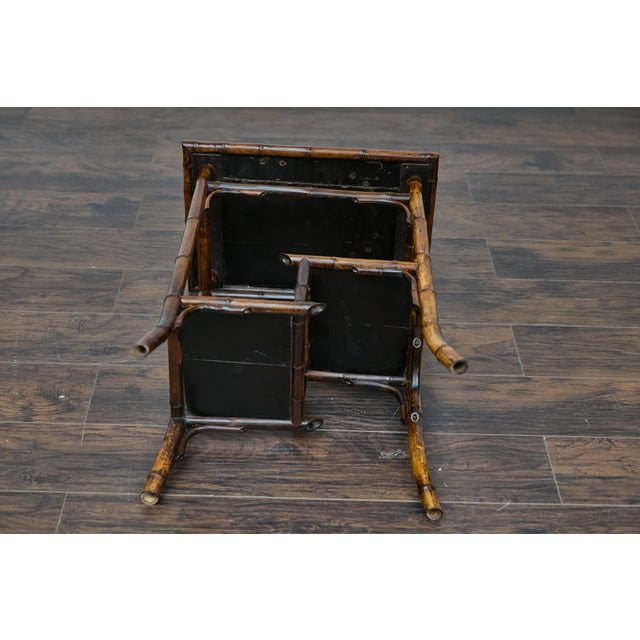An English bamboo and woven rattan side table from circa 1920 with sectioned shelves. This charming English side table...