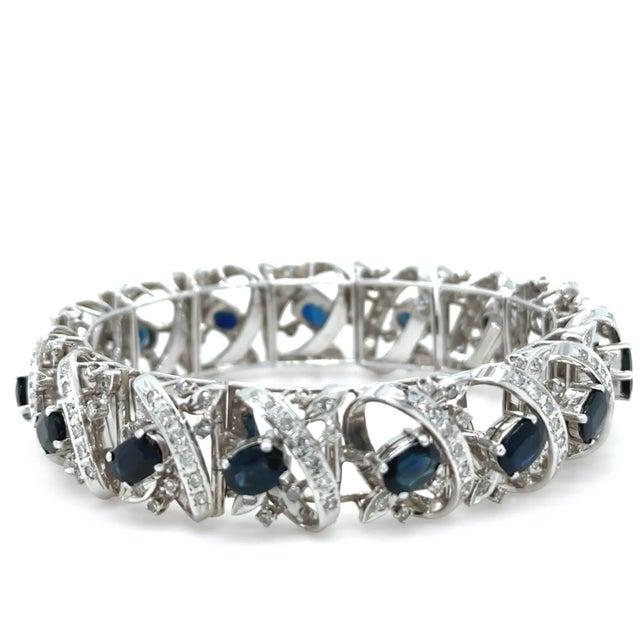 This showstopping sapphire and diamond bracelet is crafted in 14ct white gold and features a wide, articulated cluster...