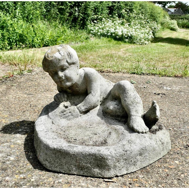 A well Weathered Garden Bird Bath with a Small Child lying on his side Playing in the Water, a lovely piece which holds a...