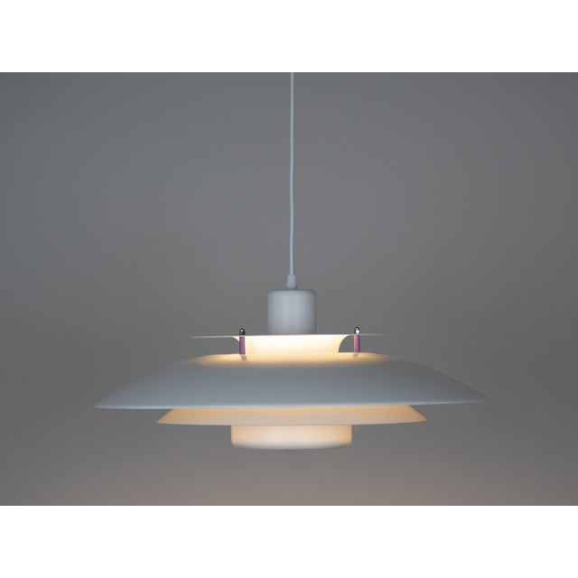 The lamp's form was designed based on the principle of a reflective system that directs light not only downward but also...