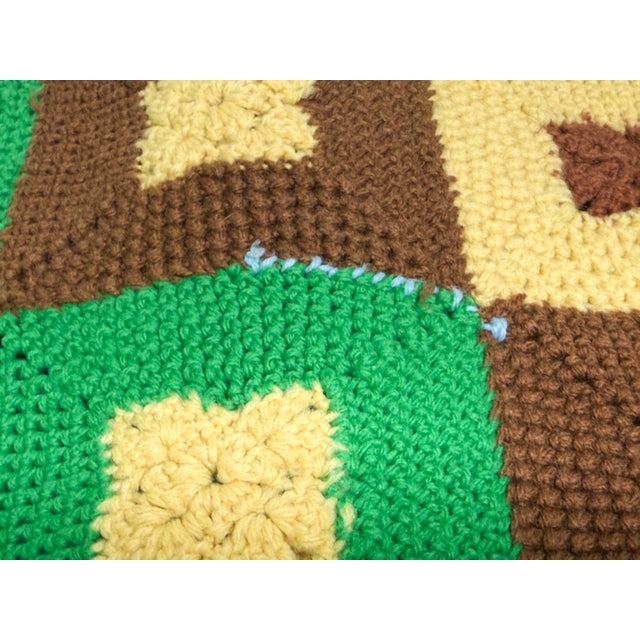 A wonderfully nostalgic vintage handmade crochet afghan featuring a striking geometric granny square design in classic...