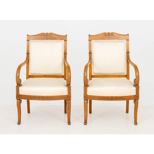 Pair of French Empire Style Walnut Arm Chairs, with scroll form crest and white silk upholstery on four scroll form legs....