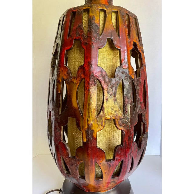 Here is a gorgeous table lamp from the mid-century featuring a pierced/cut-out design on a pottery base with an inner...