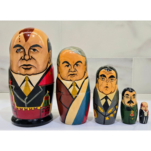 Graphic vintage set of hand-painted Russian matryoshka nesting dolls featuring late–Soviet political figures, made in...