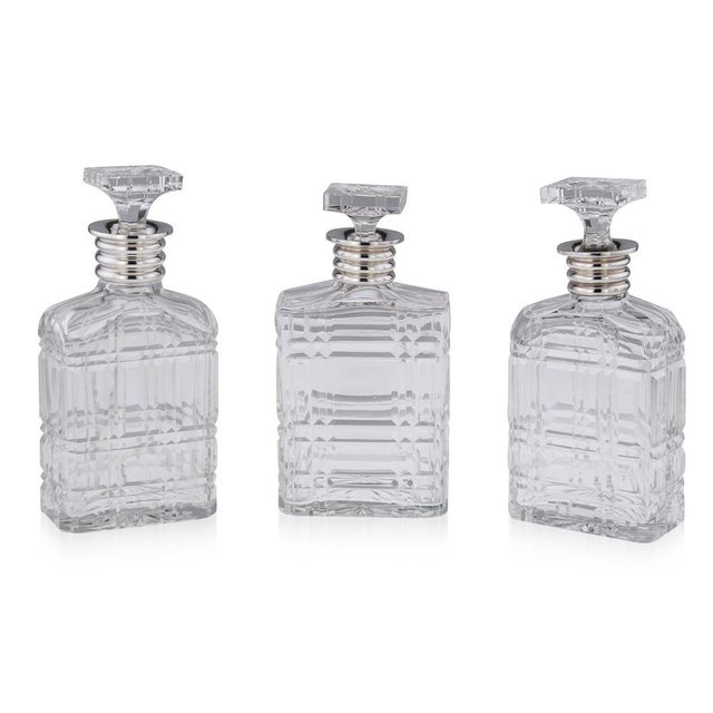 20th Century English Art Deco solid silver and cut glass set of three decanters. Of particularly large size with...