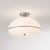 The Morelli Flush Mount is a modern ceiling light featuring a sleek satin nickel steel body and a distinctive black nickel...