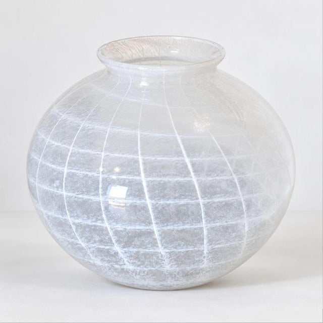 An Italian Murano glass vase from the 1950s, featuring a striking spherical form in white and transparent glass, created...
