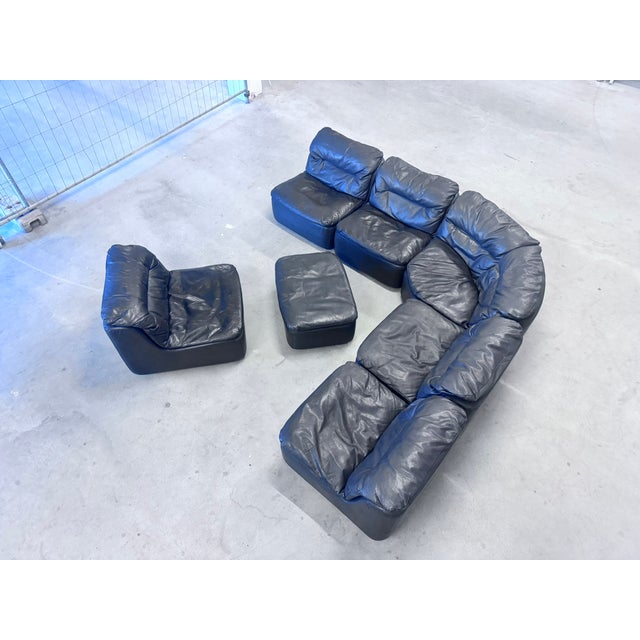 Seven-piece 1970s modular leather seating group, consisting of five seating elements, a corner element, and a footstool....