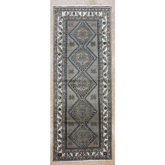 Hand-knotted runner from the Hamadan region of western Iran, featuring a series of five stepped geometric medallions...