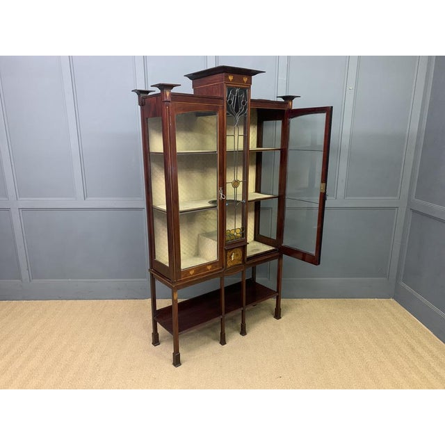 A splendid Arts and Crafts period display cabinet in the manner of Wylie and Lochhead. Of very good construction in solid...