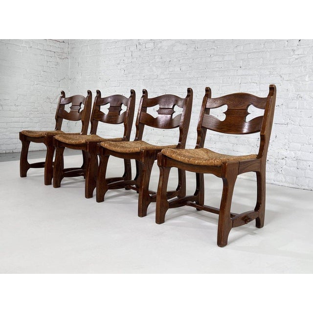 1950s Design Oak Wooden And Braided Straw Seats Set of 4 Chairs composed of a brutalist wooden structure adorned with a...