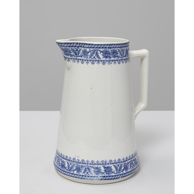 This 20th Century Belgian blue Chinoiserie ceramic pitcher features a clean, tapered silhouette enriched with finely...