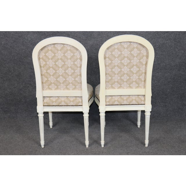 This impressive suite of painted and decorated dining chairs is conceived in the refined French Louis XVI taste,...