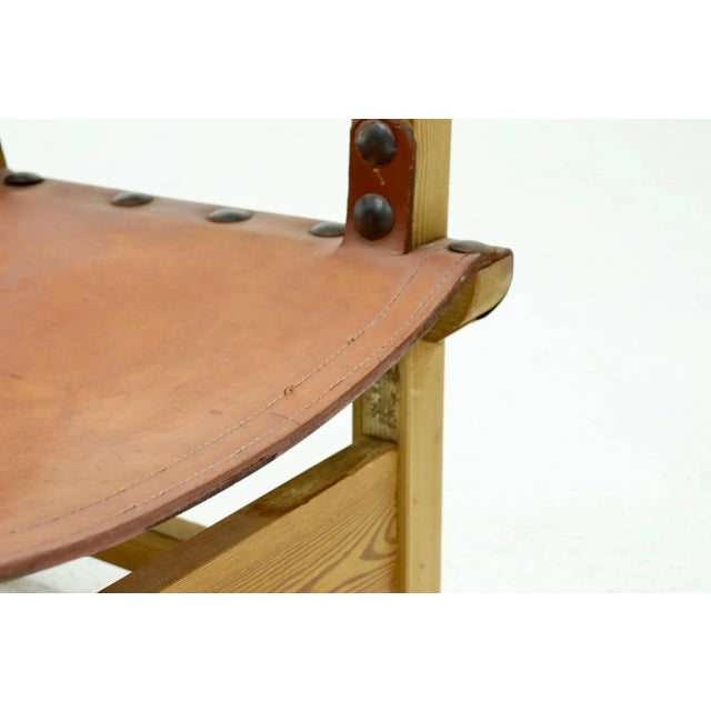 Brutalist armchair from the 1960s. The chair has a pine wooden frame and is upholstered with thick cognac saddle leather.