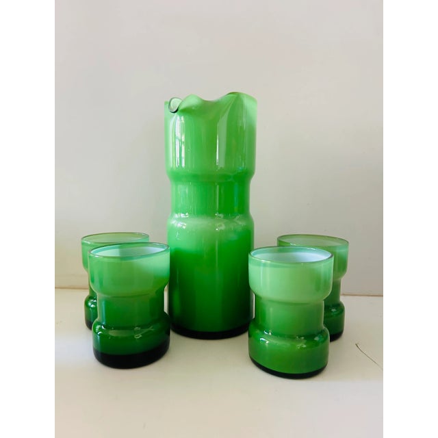 Stunning midcentury vivid green cased glass with white inside. Cocktail pitcher with 4 glasses. Most likely holmegaard...