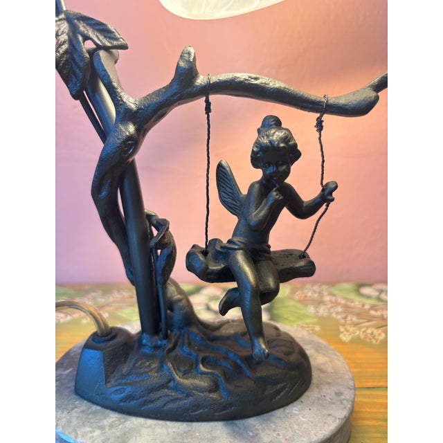 This vintage Art Nouveau table lamp by Andrea by Sadek features a charming bronze fairy sitting on a swing surrounded by...