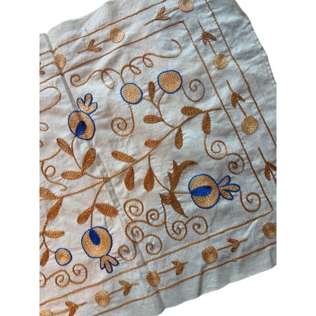 Hand-embroidered Suzani panel from Uzbekistan, worked in fine floss on a cream cotton ground. Gold and blue floral...