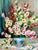 Still life of a lush arrangement of pink, white, and red flowers--hollyhocks or mallows, in a blue-patterned ceramic vase,...