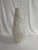 A dense and intricate texture, referring to fossils of madrepores, acts as a skeleton for this vase of Fossilia...