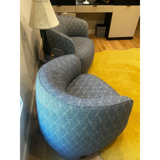 This Ligne Roset blue fabric armchair features a rounded, low-profile lounge shape with curved arms and a fully...