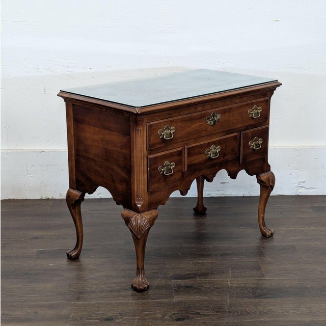 Three drawer chest with brass hardware, glass protective top, carved cabriole legs with paw feet and scalloped apron....