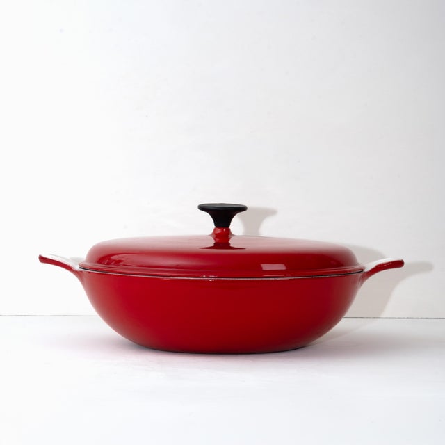 Beautiful cherry-red French midcentury braiser in excellent condition. Cast iron with red enamel exterior, white enamel...
