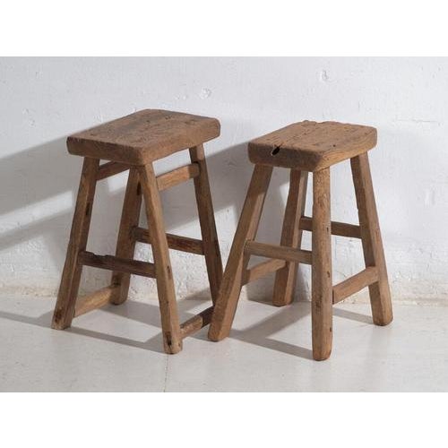 Antique Chinese stools in elm wood, crafted in China during the Qing Dynasty and dating to circa 1900. This pair embodies...