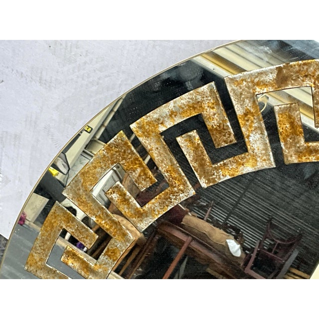 This is a late 20th century neo-classical style round mirror with faux tortoise Greek Key decoration. It is unmarked and...