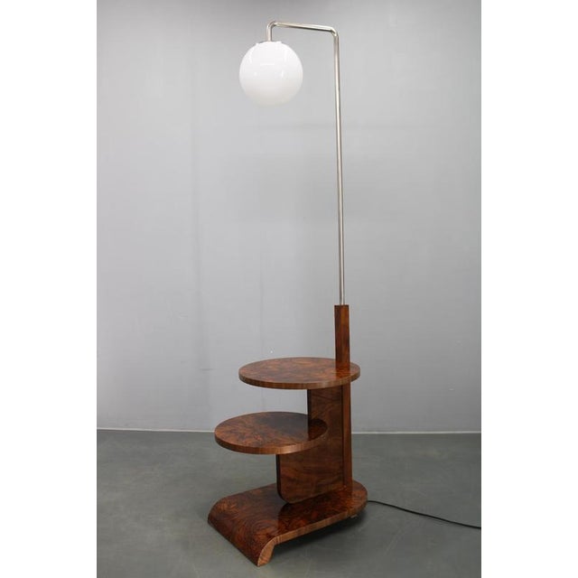 This rare art deco floor lamp with integrated shelves was produced in czechoslovakia during the 1930s and exemplifies the...