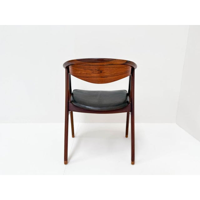This is a vintage Erik Kierkegaard chair, model 52. It has a strong rosewood frame with a curved backrest, making it...