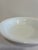 A clean-lined Corning white milk glass serving bowl with a smoothly rolled rim, marked on the underside with the dated...