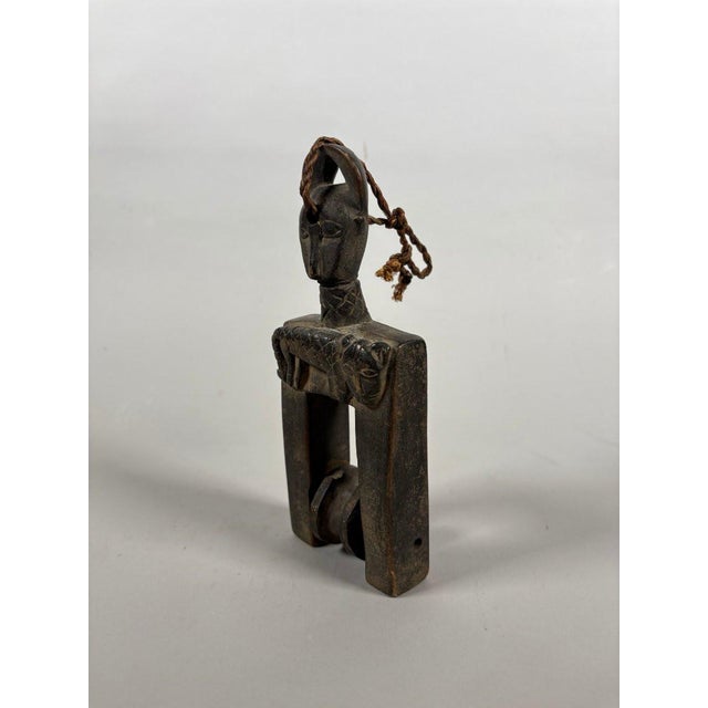 BAOULE, IVORY COAST. Loom pulley surmounted by an anthropomorphic head with a carved feline decoration at the top of the...