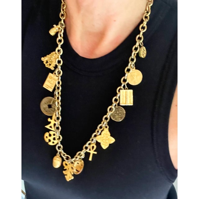 Conversation piece necklace with multiple charms representing Egyptian antiquities, Asian coins, and more. Mounted on gold...