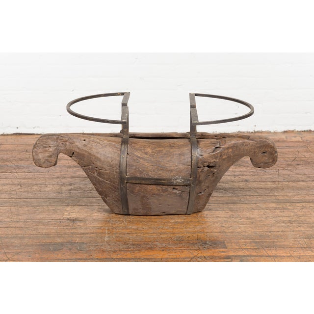 A rustic Indonesian coffee table base made of antique wooden fragment and accented with iron supports. Steeped in rustic...