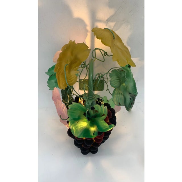 Applique, decorative wall lamp consisting of a bunch of grapes made with dark brown glass spheres tending towards...