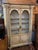 Beautiful painted cream color (with a blue undertone peeking thru) cabinet accented with earthy colors: olive green,...