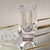 This crystal bud vase was cut to reveal gleaming facets. A colored base casts a warm glow through the crystal. Center hole...