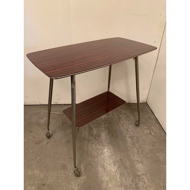 Serving table from the 1960s Chrome base with casters Shelf between the legs Good condition Dimensions: H 72 x W 75 x D 35...