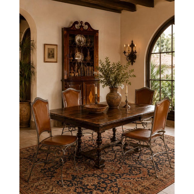 Elegant set of four Palma Brava dining chairs featuring sculptural wrought iron frames paired with rich brown leather...