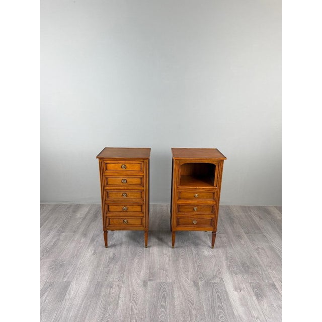An elegant pair of small chests of drawers with a warm, luminous patina. Each piece features five drawers on the front,...