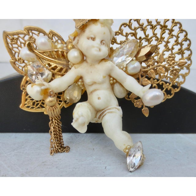 Gilt wings on an Ersatzputti. Pearls and jewels with tassels adorn a little Putti in mid-flight. Cast in an assembly held...