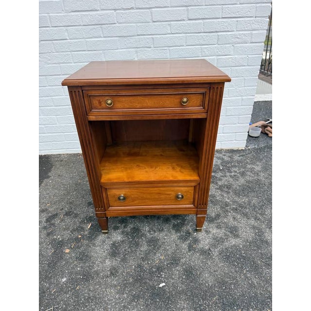 Kindel Grand Rapids Regency Style Fruitwood Nightstand. It features upper shallow drawer, an open shelf area, and an...