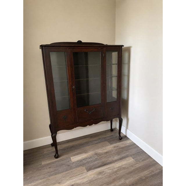 Vintage early-mid 20th Queen Anne-style mahogany china cabinet with a rich dark wood finish and graceful cabriole legs....