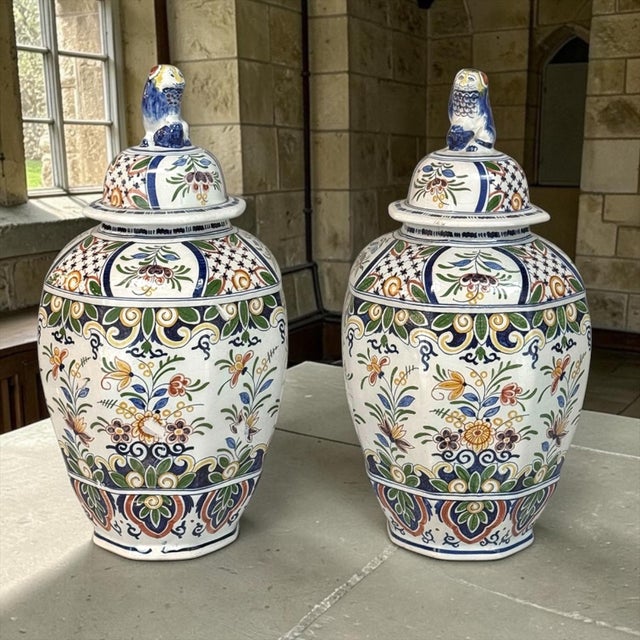 Graceful in form and richly detailed, this pair of Boch Frères Keramis lidded urns has remained in a private collection...