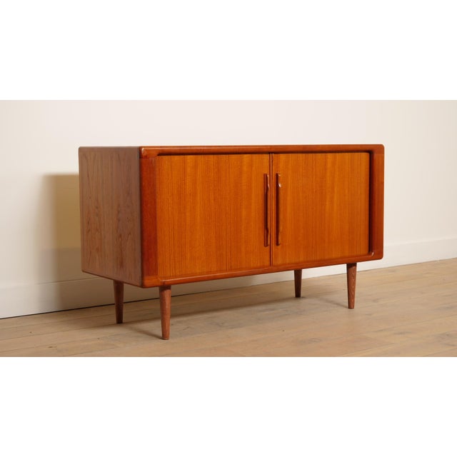 This vintage wall cabinet is ideally sized and crafted from teak. This practical, compact sideboard features two tambour...