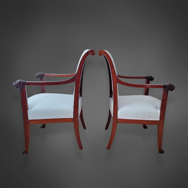 A beautiful pair of Empire armchairs from the early 19th century, crafted from solid mahogany. The armchairs are of high...